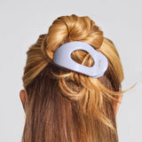 Hair tie in a bun on a person with a plain background
