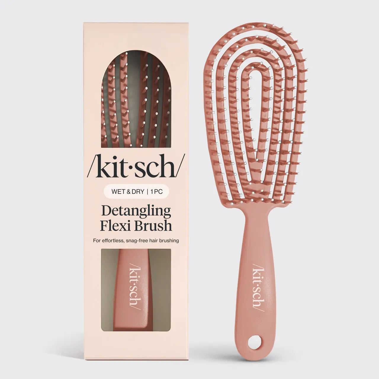 A Kitsch Detangling Flexi Brush shown next to its retail box. The brush has a dusty rose handle and flexible bristles, while the packaging is a pale peach-beige color with white branding.