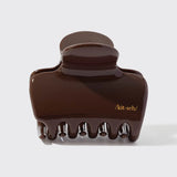 Brown hair clip with 'kit-sch' branding on a white background from Nespoli Jewelers.