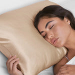 Woman sleeping peacefully with a beige pillow on a light background