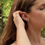 Woman wearing FYB silver hoop earrings with clear CZ accents and coordinating stud earrings