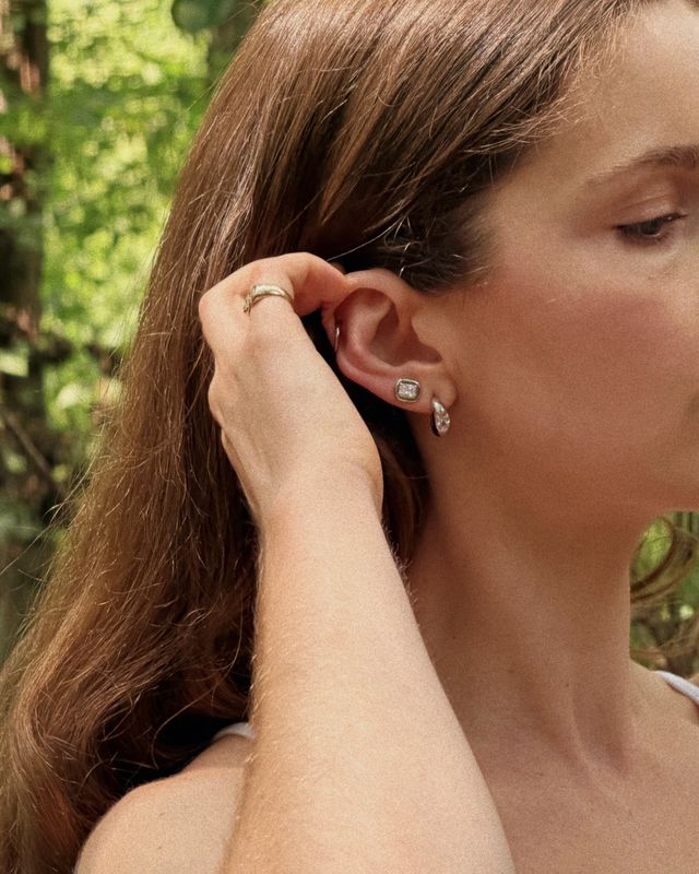 Woman wearing FYB silver hoop earrings with clear CZ accents and coordinating stud earrings