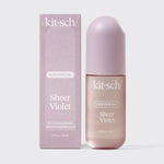 Kit Sch Sheer Violet hair perfume bottle next to its matching lavender box, featuring a rounded cap and a soft pinkish-purple tinted bottle on a light gray background.