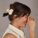 Woman with a hair clip and a neutral background from Nespoli Jewelers.