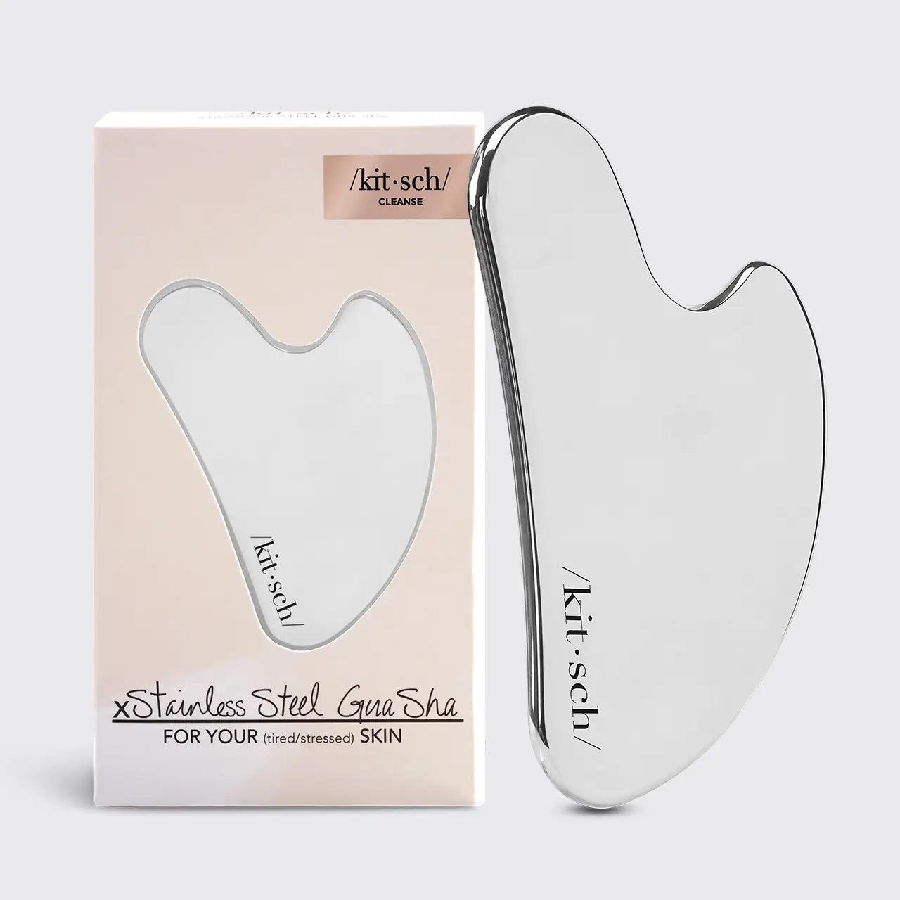 Gua Sha tool with packaging on a light gray background