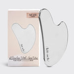Gua Sha tool with packaging on a light gray background