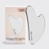 Gua Sha tool with packaging on a light gray background