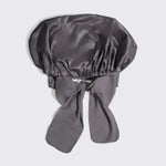 Gray satin bonnet with a bow on a light gray background