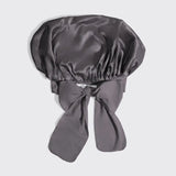 Gray satin bonnet with a bow on a light gray background