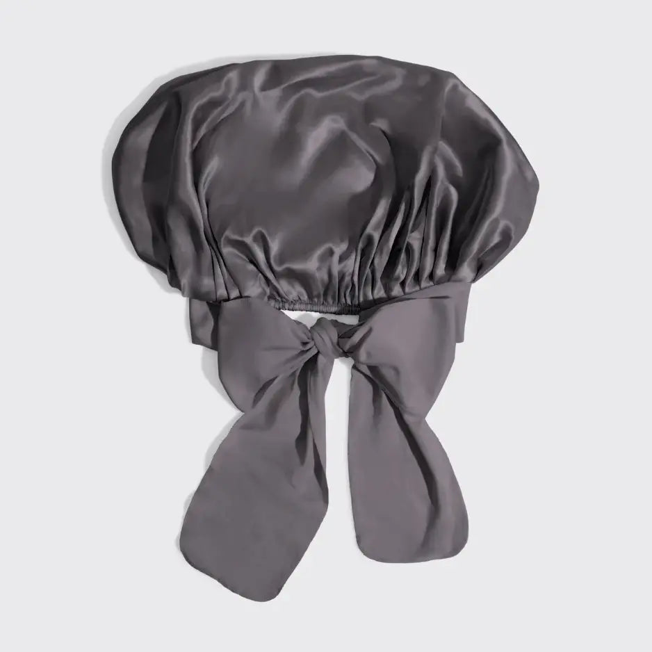 Gray satin bonnet with a bow on a light gray background