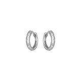 Silver huggie hoop earrings with small engraved details on a white background.
