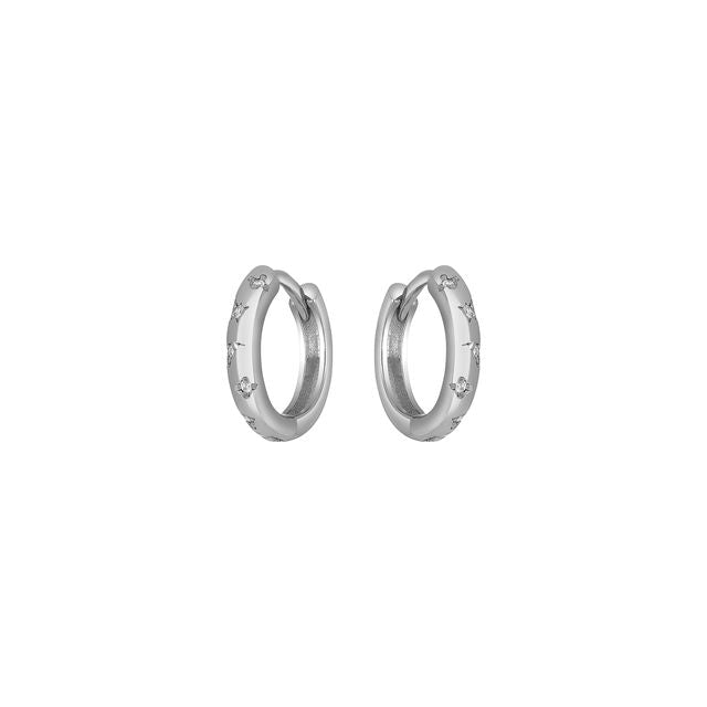 Silver huggie hoop earrings with small engraved details on a white background.