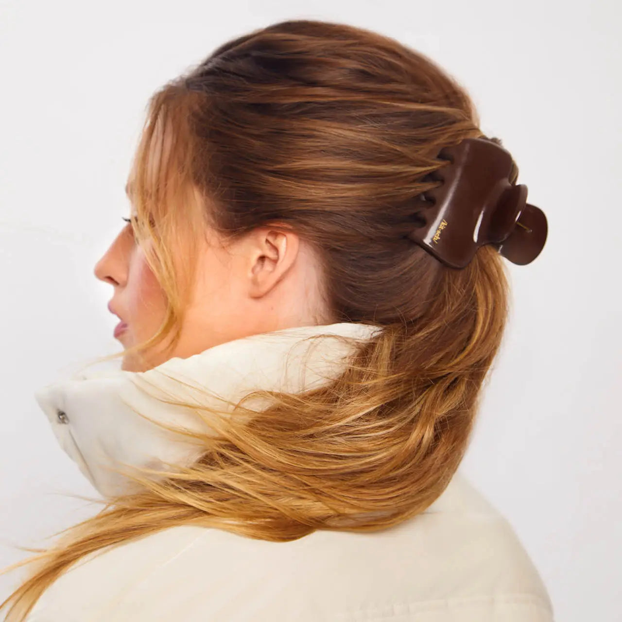 Woman with hair styled using a hair clip on a white background from Nespoli Jewelers.