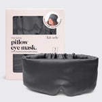 A dark gray satin pillow eye mask displayed in front of its light pink packaging box. The box features a window showing the matching dark gray mask inside and includes branding for 'kit·sch'.