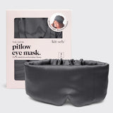 A dark gray satin pillow eye mask displayed in front of its light pink packaging box. The box features a window showing the matching dark gray mask inside and includes branding for 'kit·sch'.