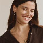 Woman wearing FYB gold dangle earrings with clear CZ stones