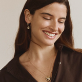 Woman wearing FYB gold dangle earrings with clear CZ stones