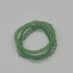 Green beaded bracelet on a light gray background