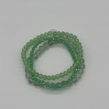 Green beaded bracelet on a light gray background