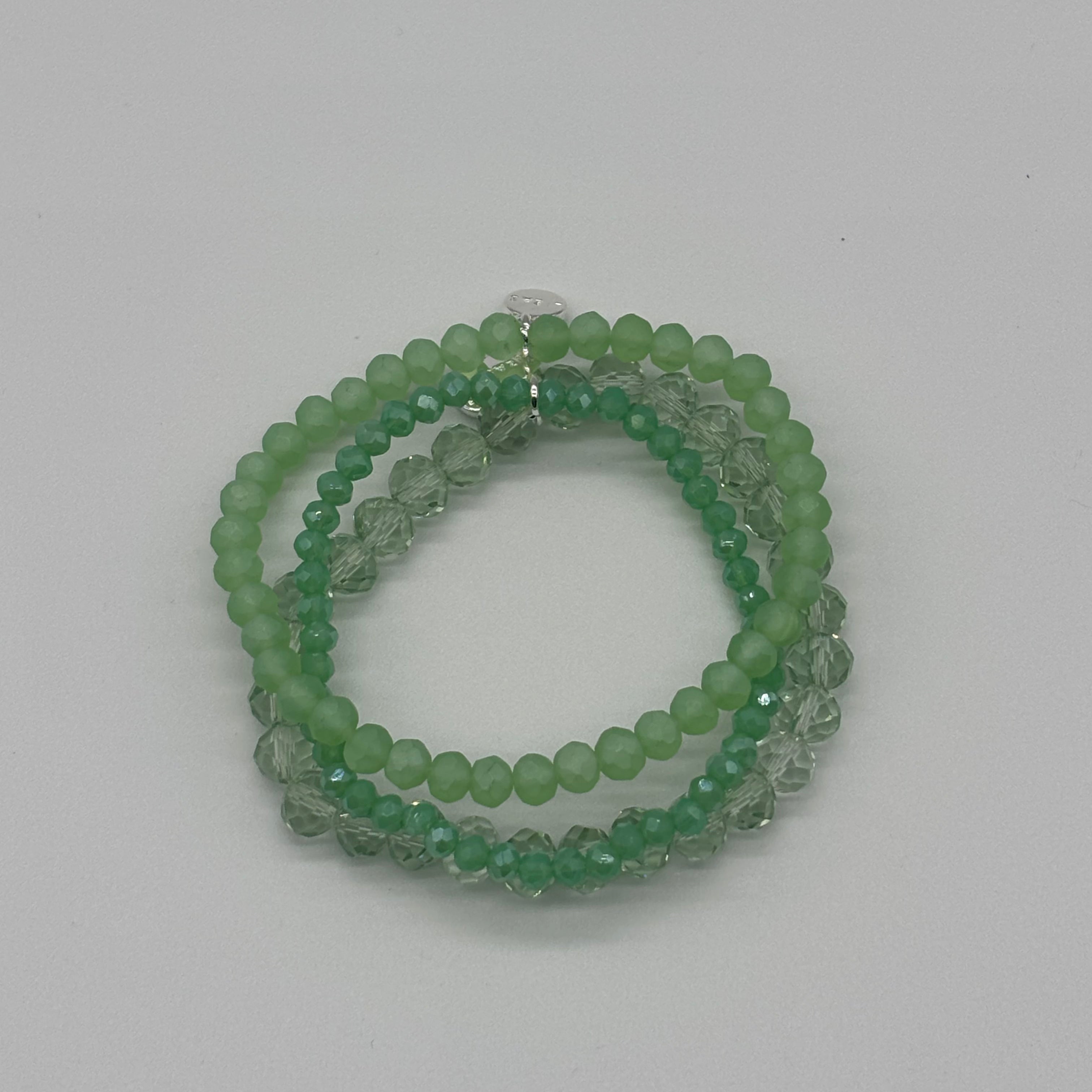 Green beaded bracelet on a light gray background
