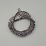 Stack of beaded bracelets on a light gray background
