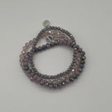 Stack of beaded bracelets on a light gray background