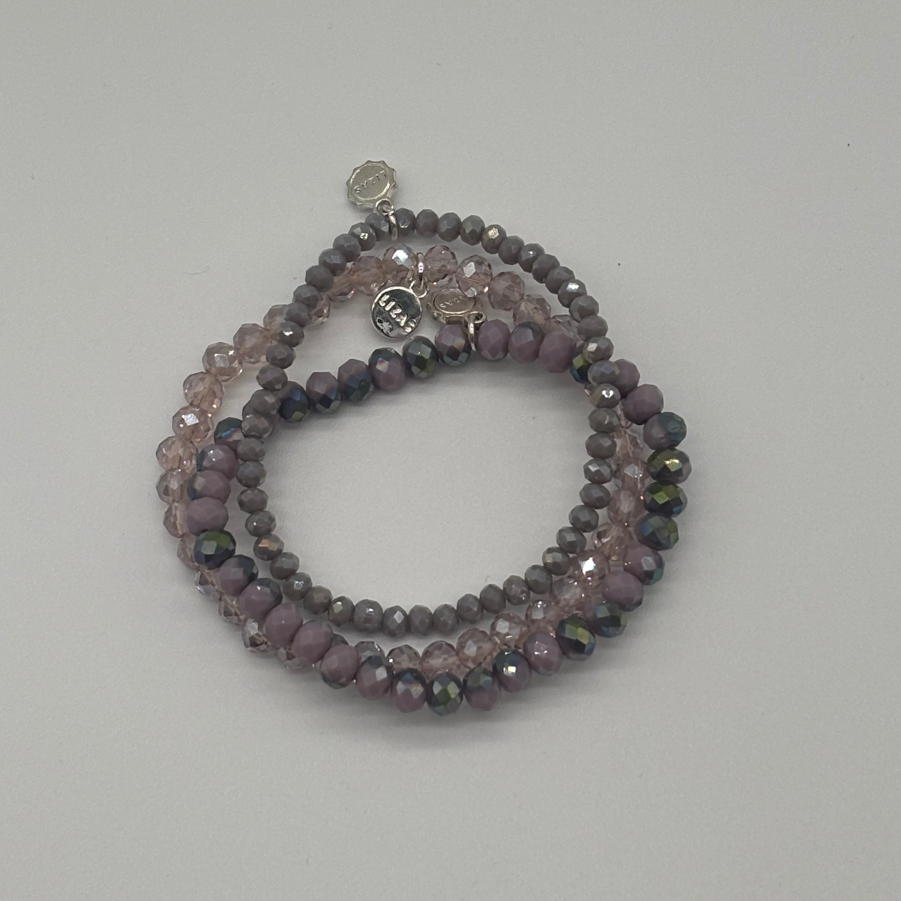Stack of beaded bracelets on a light gray background