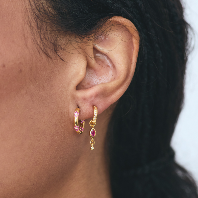 Woman wearing FYB gold hoop earrings with pink and clear CZ floral  accents