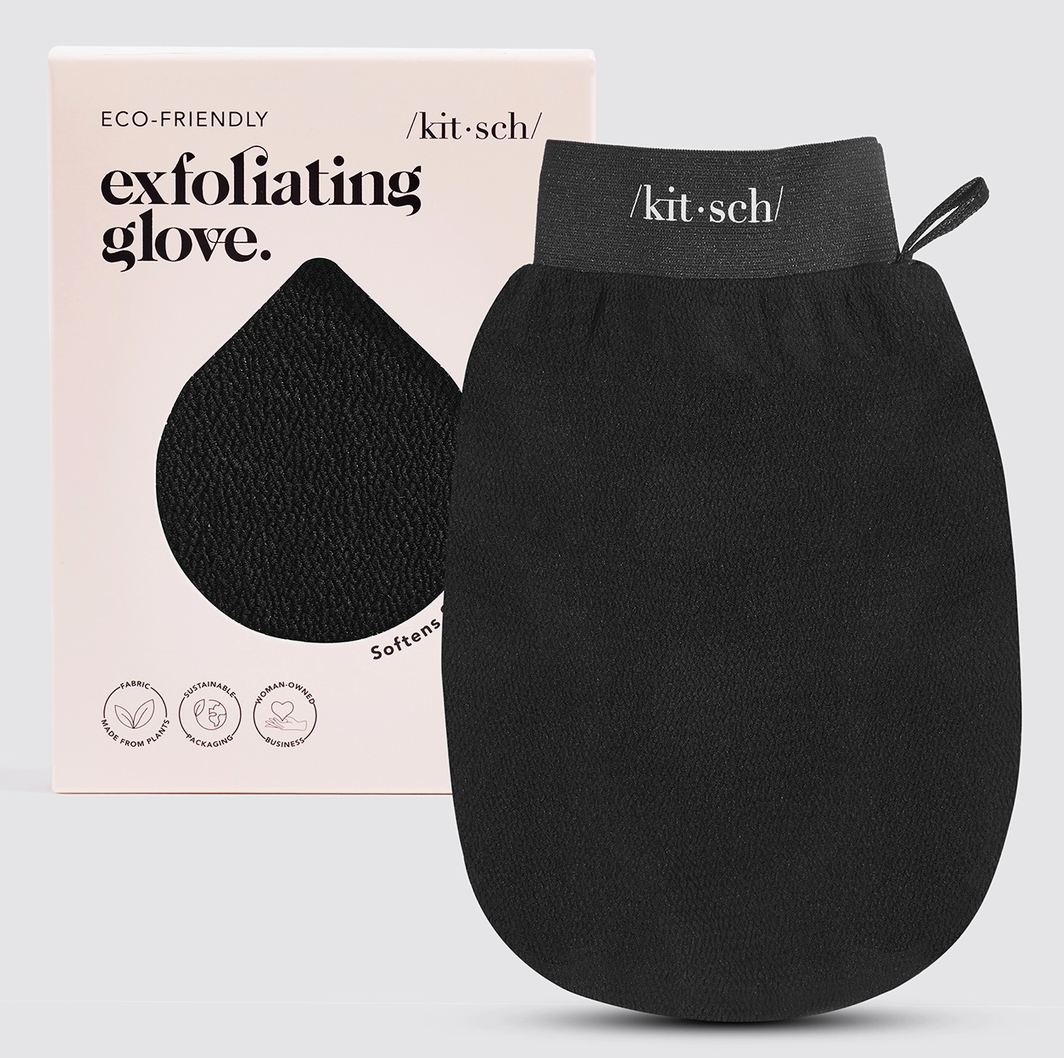 A black exfoliating glove from the brand kit-sch, shown next to its light pink packaging box on a light gray background.
