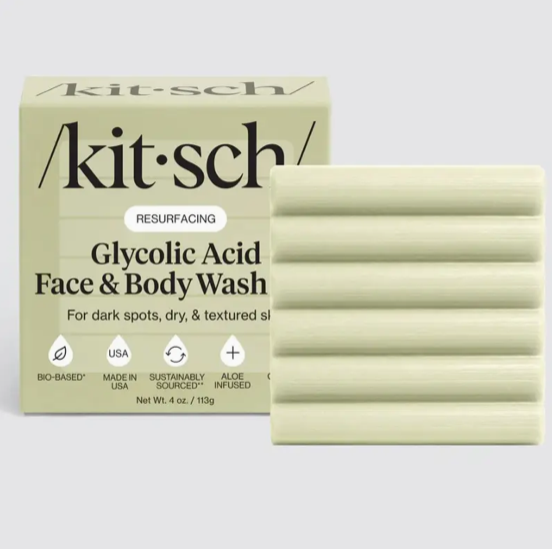 Kit Sch Resurfacing Glycolic Acid Face & Body Wash shown with its beige box and two pale yellow-green soap bars on a light gray background.