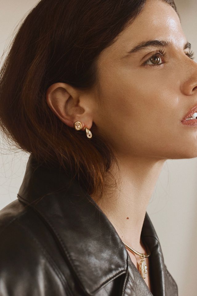 Woman wearing FYB gold stud earrings with clear CZ stones in a layered earring look