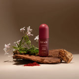 Kit-sch bottle of Oak & Amber on a wooden platform with flowers and natural elements.