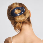 Person with a blue hair clip in their hair on a light gray background from Nespoli Jewelers
