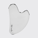 Silver facial gua sha tool with 'kit-sch' branding on a light gray background