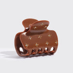 Brown hair clip with decorative elements on a white background from Nespoli Jewelers.