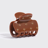 Brown hair clip with decorative elements on a white background from Nespoli Jewelers.