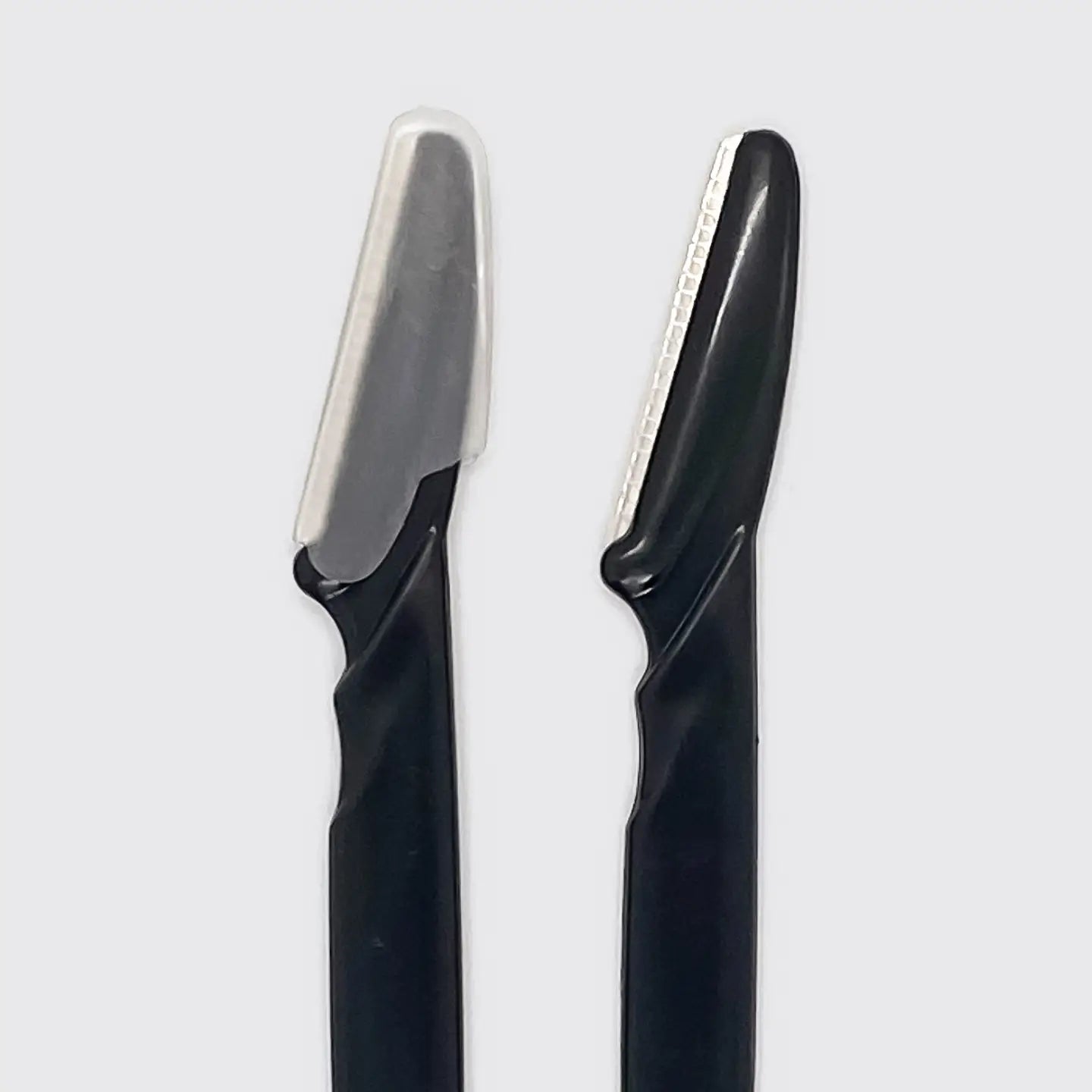 Two black grooming razors with silver metal blades, shown side-by-side against a light gray background.