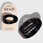 A glossy black flat cloud clip hair accessory shown next to its beige retail packaging card. The card features the Kit sch brand name and gold foil accents, with the product itself printed with 'All-Day Hold' and 'Ready'.