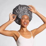 Woman wearing a gray satin hair wrap against a plain background